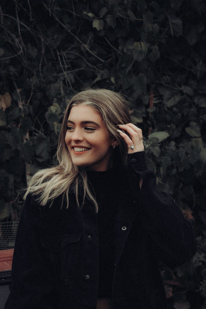 woman smiling while looking around in a garden