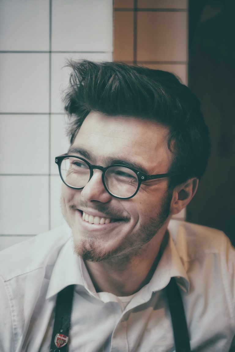 man with glasses and suspenders smiling